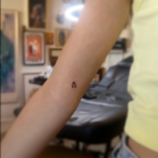 Tiny Fine Line Ladybug Tattoo on Women Arm by @sonnhy