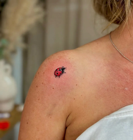 Tiny Fine Line Ladybug Tattoo on Women Shoulder by @nickyhilltatts