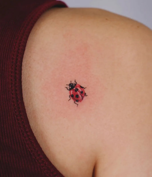 Tiny Fine Line Ladybug Tattoo on Women Shoulder by @soulpurposetattoo