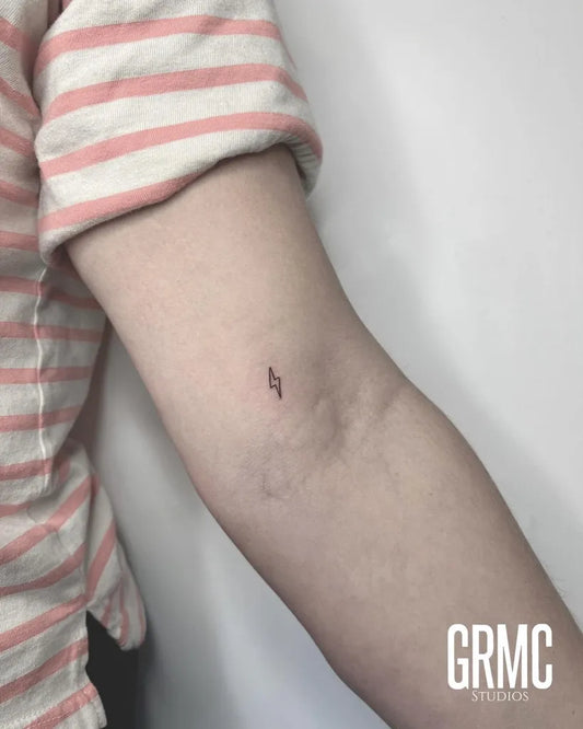 Tiny Fine Line Lightning Bolt Tattoo on Women Arm by @grmcstudios