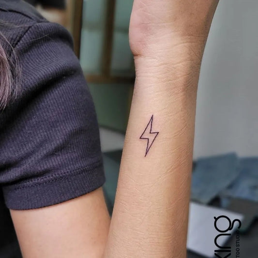 Tiny Fine Line Lightning Bolt Tattoo on Women Wrist by @xingtattoo_blr