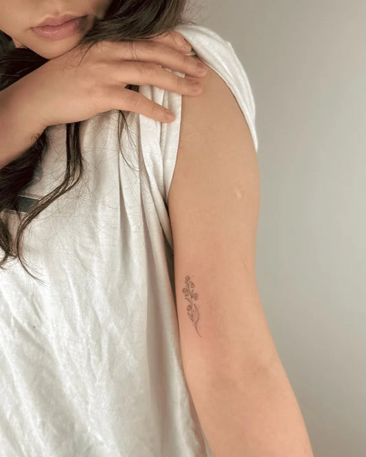 Tiny Fine Line Lily of the Valley on Women Arm Tattoo by @moha.tattoo