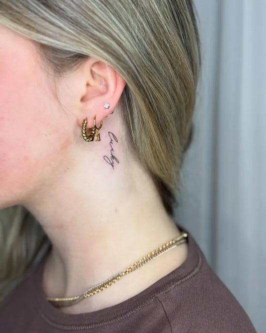 Tiny Fine Line Lucky Word Tattoo on Women Behind the Ear by @cherryy_tattoos