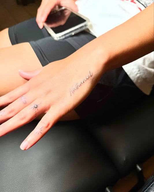 Tiny Fine Line Script Word on Women Hand Tattoo by @amable.ink