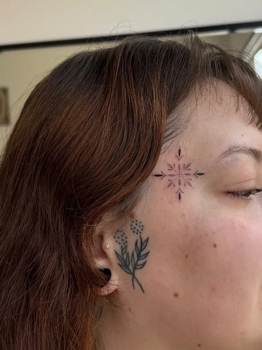 Tiny Fine Line Star and Flowers on Women Face Tattoo by @iggy_inktattooist