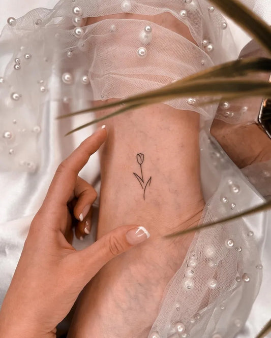 Tiny Fine Line Tulip Tattoo on Women Arm by @tinytattoos_feathertouch