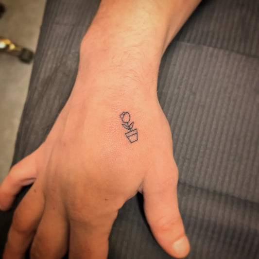 Tiny Fine Line Tulip in Pot Tattoo on Men Hand by @yatush
