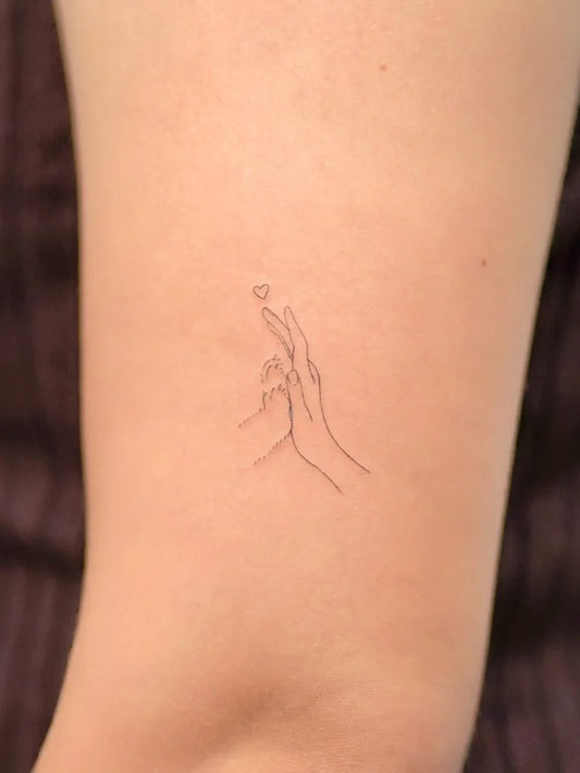 Tiny Fine Line Two Hands Reaching for Heart on Women Arm Tattoo by @cipri.tatt