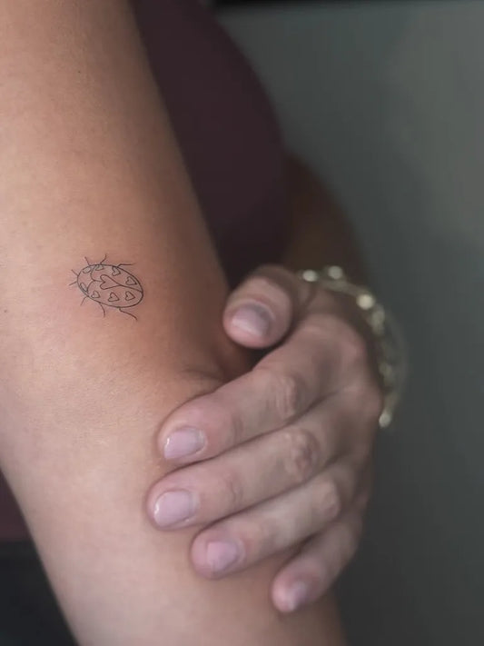Tiny FineLine Ladybug on Women Arm Tattoo by @tigerlilyink