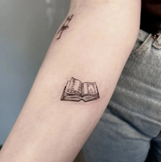 Tiny Linework Open Book on Women Arm Tattoo by @descriptive_art_collective