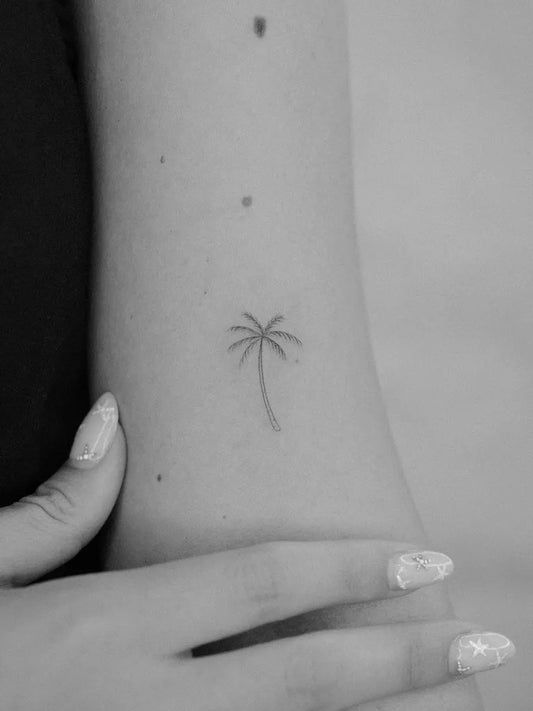 Tiny Linework Palm Tree Tattoo on Women Arm by @pelininaydin