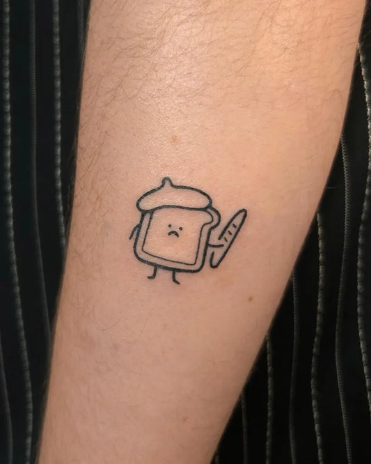 Tiny Linework Toast with Beret and Baguette on Women Arm Tattoo by @lazythom_
