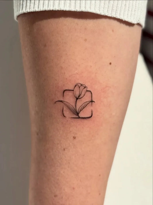 Tiny Linework Tulip in Square Tattoo on Women Thigh by @sablii.tattoo