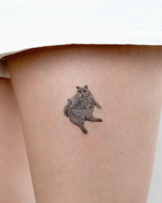Tiny Micro Realism Fluffy Cat on Women Thigh Tattoo by @e.ple_tattoo