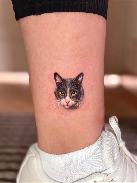 Tiny Micro Realism Gray Cat Face on Women Leg Tattoo by @mar.tatuadora