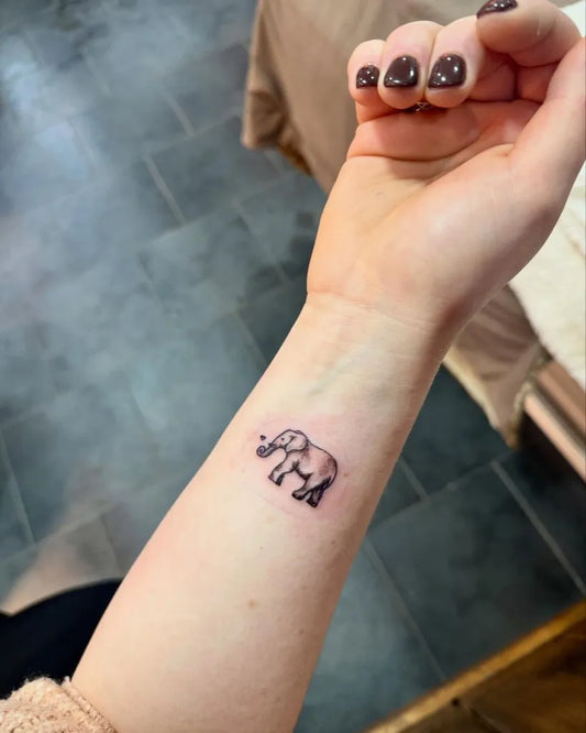Tiny Minimal Elephant Tattoo on Women Wrist by @black.pearltattooparlour