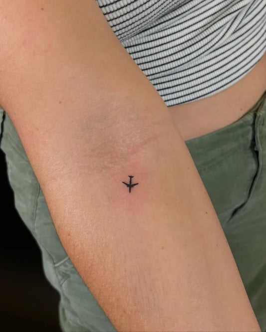 Tiny Minimalist Airplane on Women Arm Tattoo by @oahu_tattoo