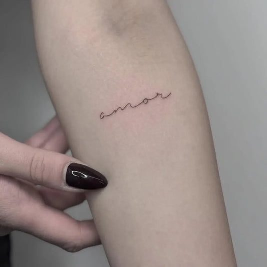 Tiny Minimalist Amor Word on Women Arm Tattoo by @elephantattoo.ar