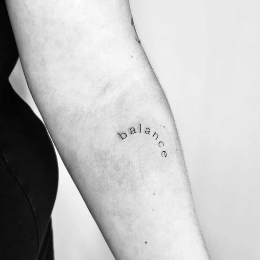 Tiny Minimalist Balance Word on Women Arm Tattoo by @tatsbytvg