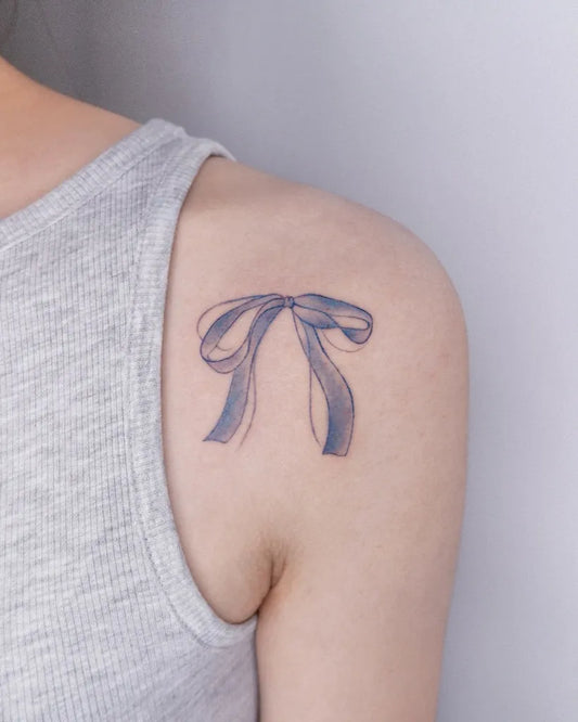 Tiny Minimalist Blue Bow on Women Shoulder Tattoo by @its.freegee
