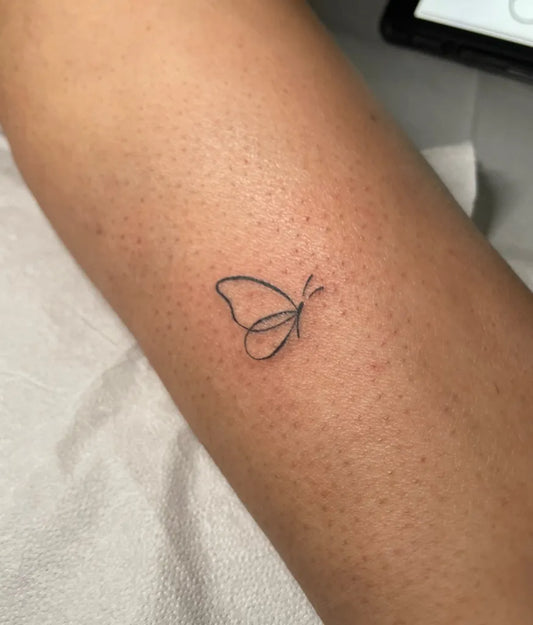 Tiny Minimalist Butterfly on Women Forearm Tattoo by @drew.letters