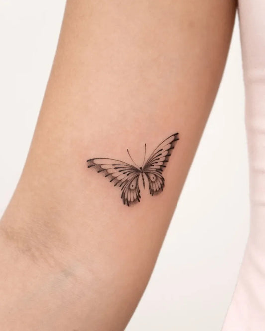 Tiny Minimalist Butterfly on Women Upper Arm Tattoo by @solyn_tattooist