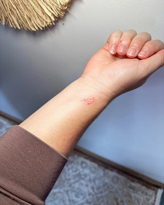 Tiny Minimalist Cardinal Tattoo on Women Wrist by @labellasalonn