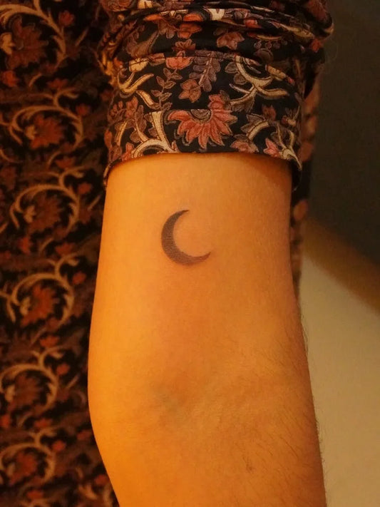Tiny Minimalist Crescent Moon Tattoo on Women Arm by @urban.ink.in