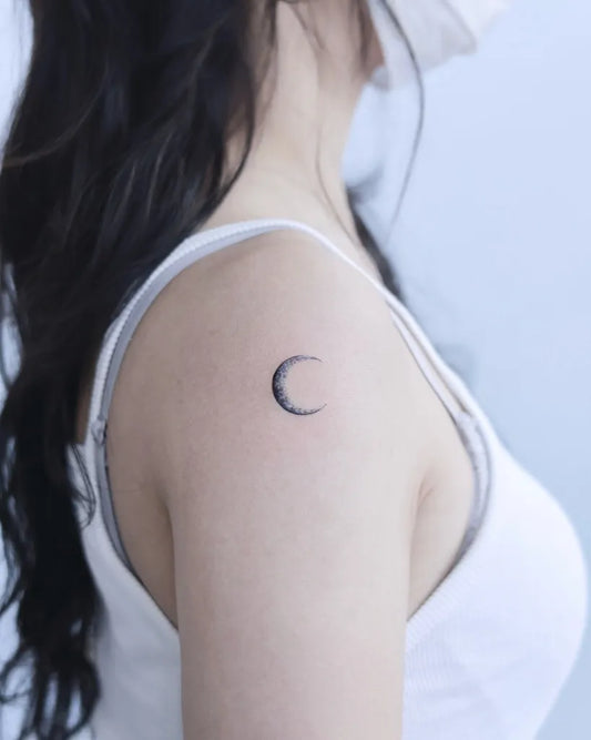 Tiny Minimalist Crescent Moon Tattoo on Women Shoulder by @matt_tattooist