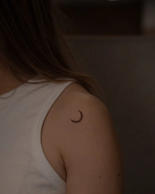 Tiny Minimalist Crescent Moon Tattoo on Women Shoulder by @mid.ttt