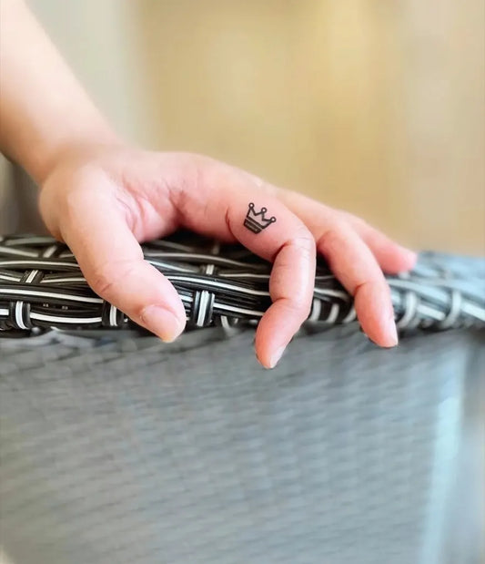 Tiny Minimalist Crown Tattoo on Women Finger by @artinktouch