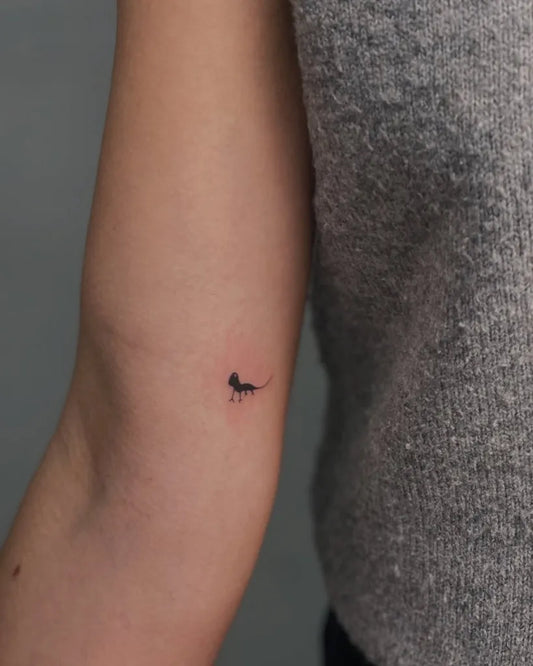 Tiny Minimalist Dinosaur on Women Arm Tattoo by @la_ta_ttuu