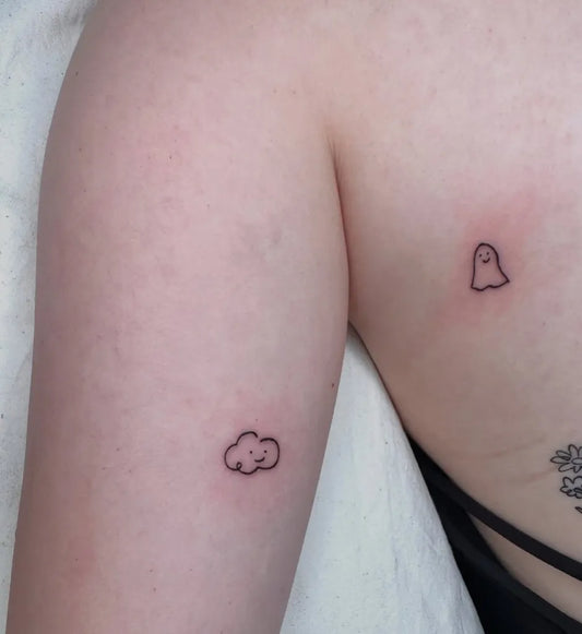 Tiny Minimalist Ghost and Cloud Tattoo on Women Upper Arm by @lorimori_tattoo