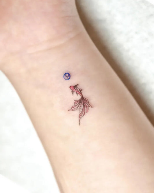 Tiny Minimalist Goldfish Semicolon on Women Wrist Tattoo by @tattooist_yuca