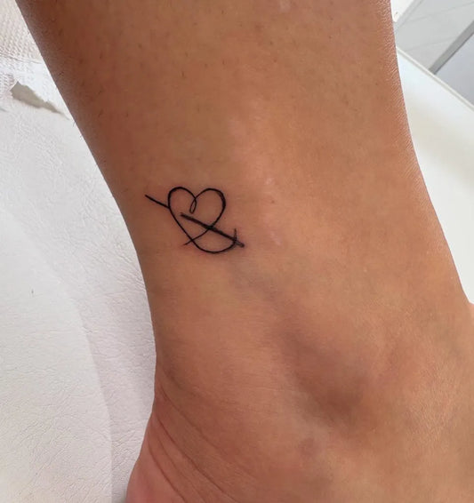 Tiny Minimalist Heart and Arrow on Women Ankle Tattoo by @beauty_and_the_inked