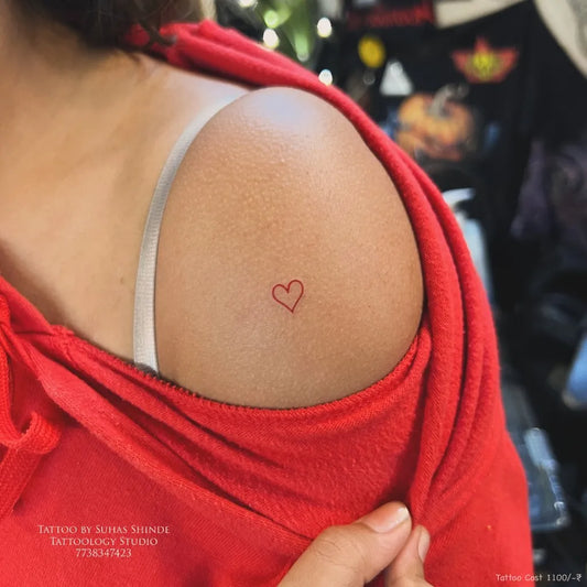 Tiny Minimalist Heart on Women Shoulder Tattoo by @tattoology_studio