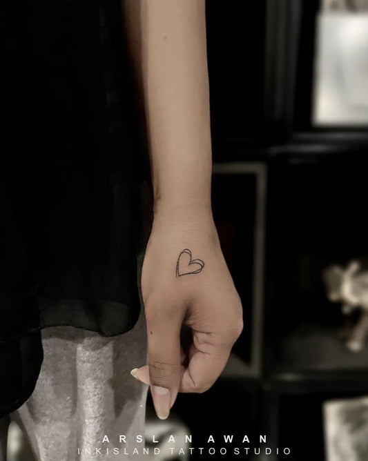 Tiny Minimalist Heart on Women Wrist Tattoo by @inkisland.studio