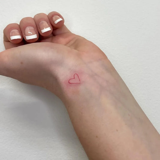 Tiny Minimalist Heart on Women Wrist Tattoo by @iris.tats