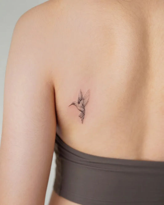 Tiny Minimalist Hummingbird on Women Shoulder Tattoo by @take.a.tatt