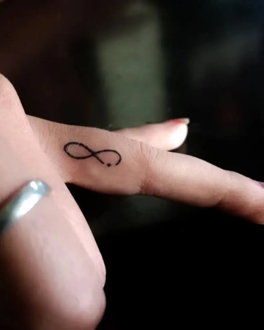 Tiny Minimalist Infinity Tattoo on Women Finger by @av_tattoos_art
