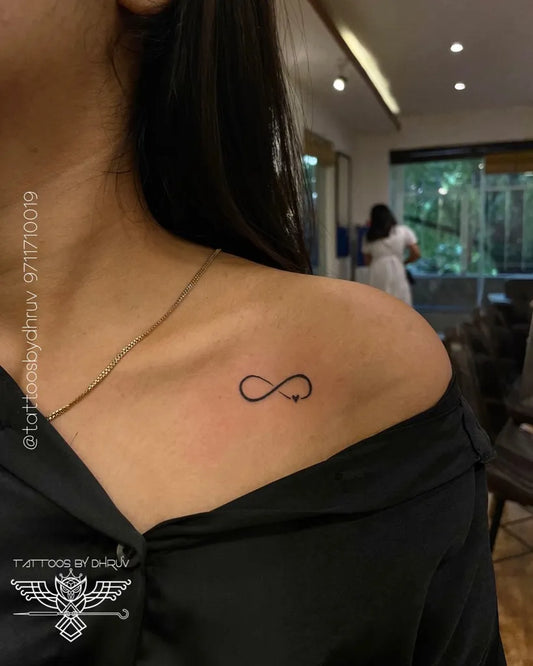 Tiny Minimalist Infinity Tattoo on Women Shoulder by @tattoosbydhruv