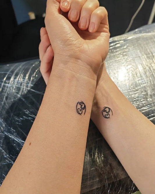 Tiny Minimalist Interlocking Hearts on Women Wrist Tattoo by @funky_tattoo_bucuresti