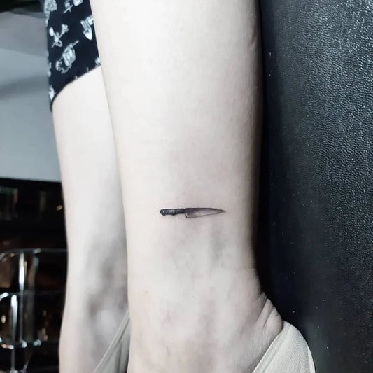 Tiny Minimalist Knife Tattoo on Women Ankle by @cjdupitas