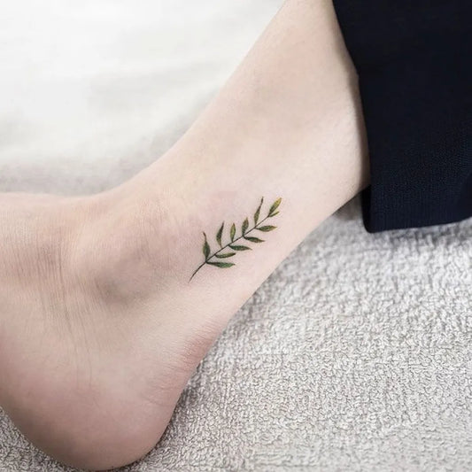 Tiny Minimalist Laurel Leaf on Women Ankle Tattoo by @treatyjewellery