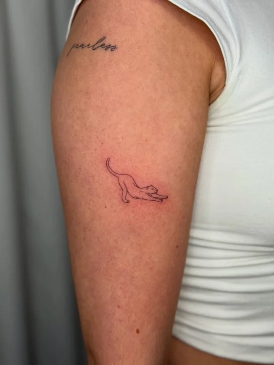 Tiny Minimalist Leaping Cat on Women Arm Tattoo by @cherryy_tattoos