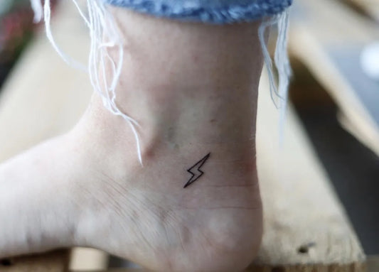 Tiny Minimalist Lightning Bolt Tattoo on Women Ankle by @chtattooing
