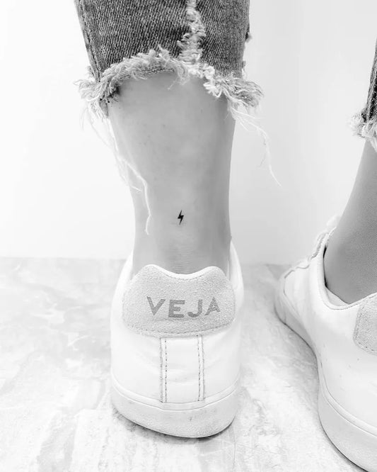 Tiny Minimalist Lightning Bolt Tattoo on Women Ankle by @tatuajespequenos
