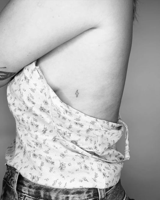 Tiny Minimalist Lightning Bolt Tattoo on Women Rib by @j.h.ditchfield_tattoo
