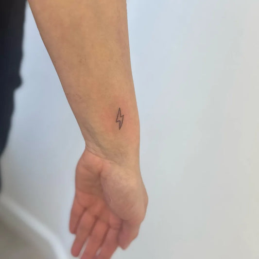 Tiny Minimalist Lightning Bolt Tattoo on Women Wrist by @taylorstinytattoos