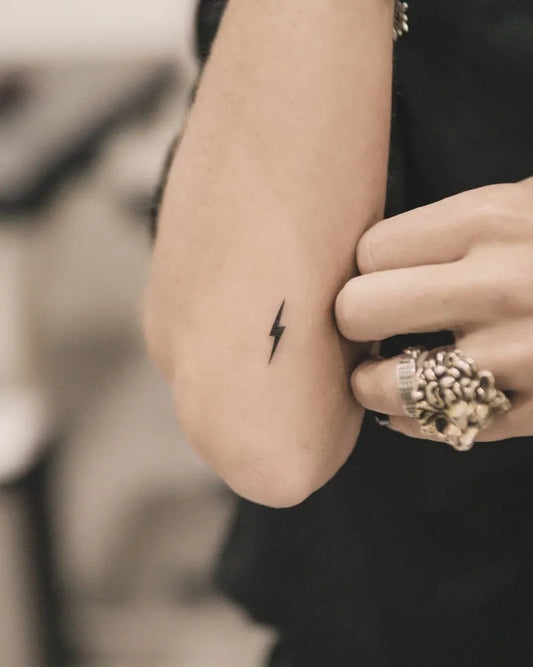Tiny Minimalist Lightning Tattoo on Women Elbow by @joeysneedle